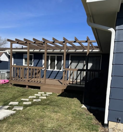 Dark brown stained deck with pergola attached to blue house in Decatur, IL