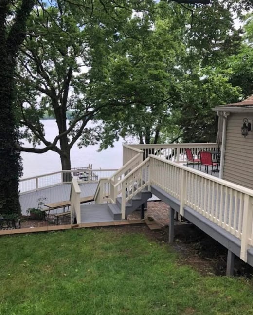 Multi-level painted deck with white railings overlooking a lake in Decatur, IL