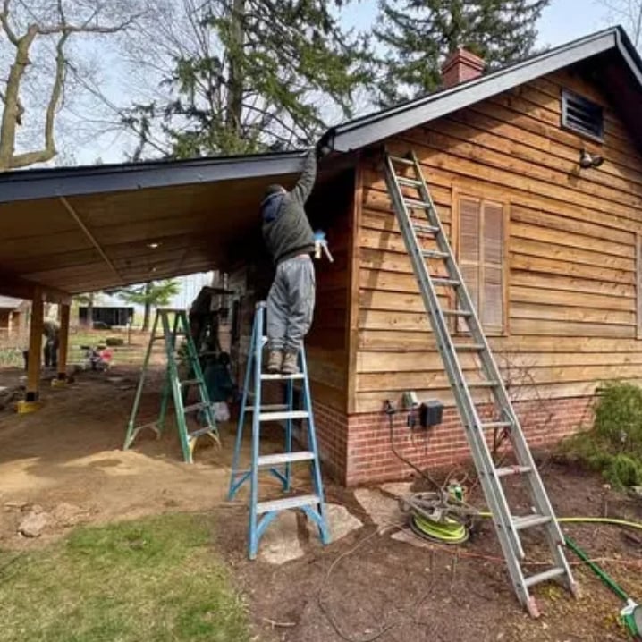 Clean Cut Painting & Handyman worker on ladder doing exterior prep work on wood siding home in Springfield Illinois