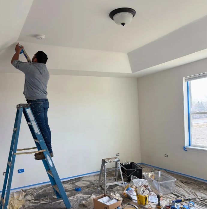 Clean Cut Painting & Handyman painter on ladder cutting in ceiling trim inside a Springfield Illinois home