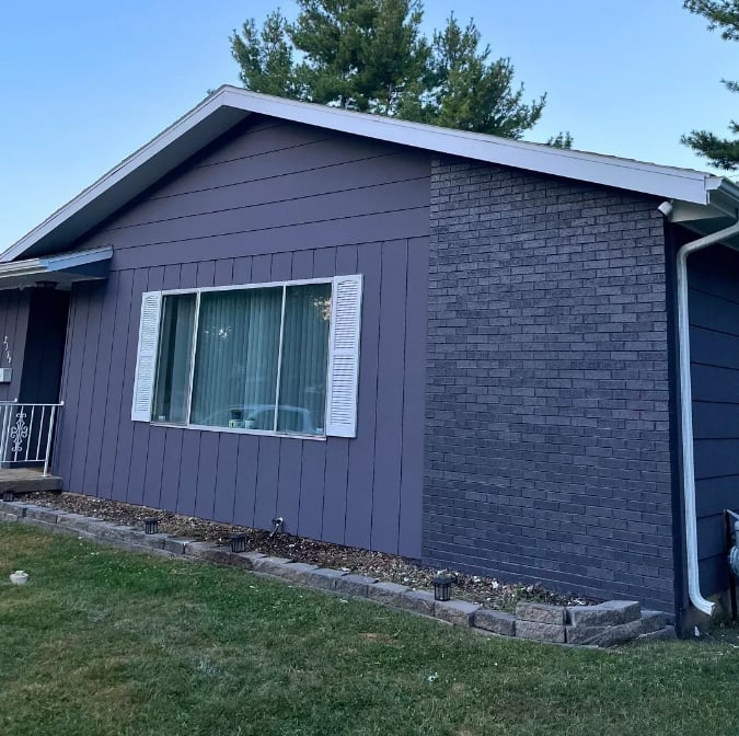 Clean Cut Painting & Handyman exterior painting project in Springfield Illinois - ranch home with deep purple siding, white shutters and brick accent wall